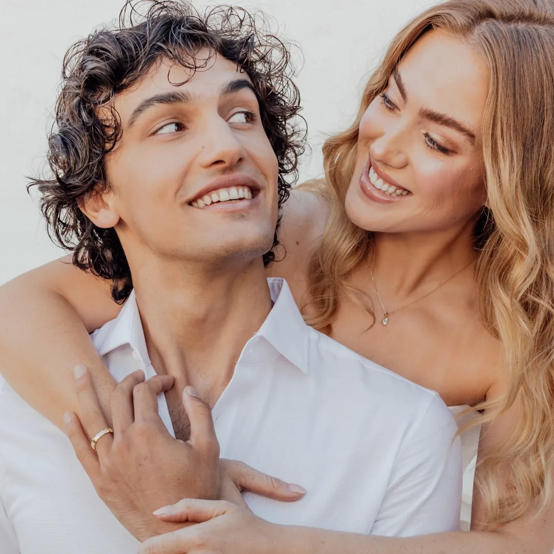 A couple together, a RAUSCHMAYER wedding band on his hand