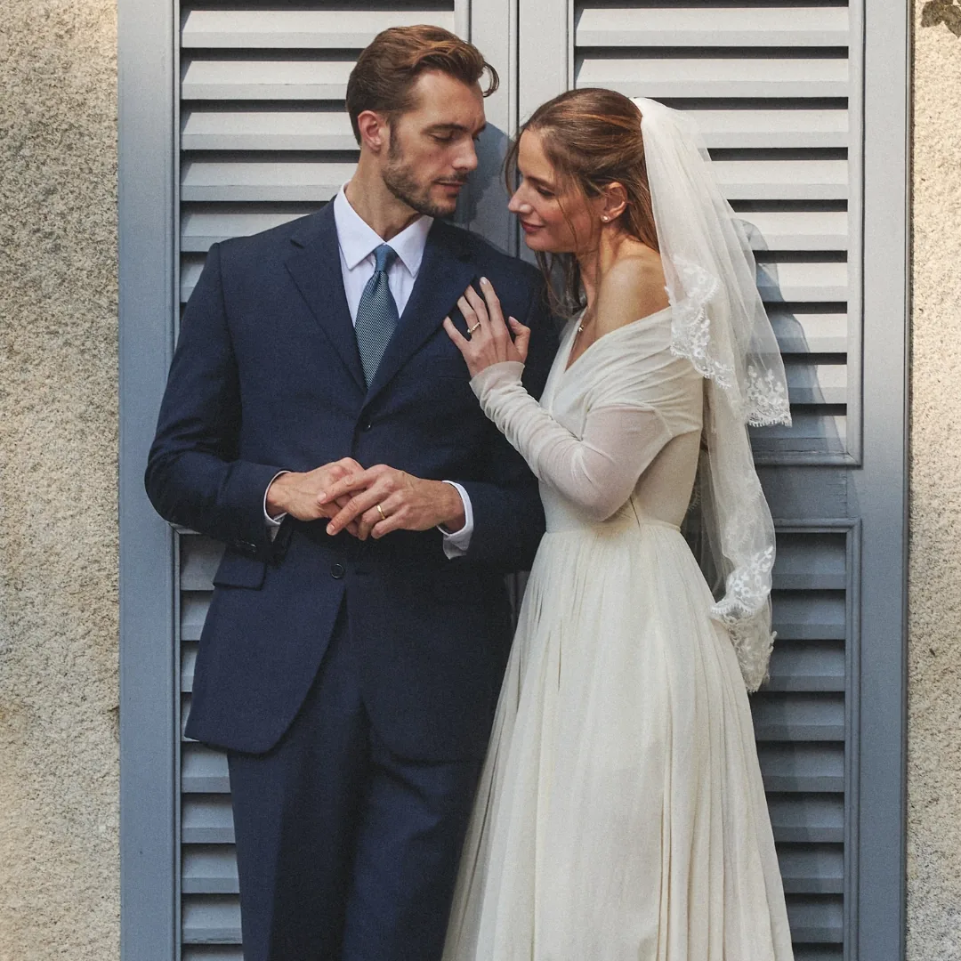 A bride and groom together, wearing RAUSCHMAYER wedding bands